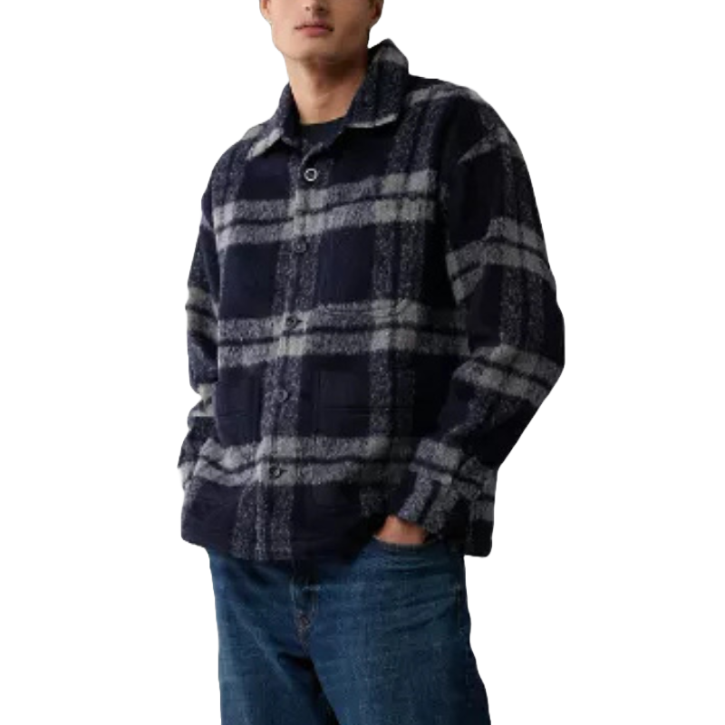 Dark plaid shirt jacket with a button-up front and two side pockets, featuring a black and grey checkered pattern. Worn with blue jeans.