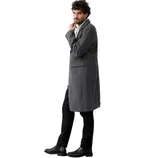 A man wearing a long, gray overcoat with black pants and black leather boots, standing against a white background.