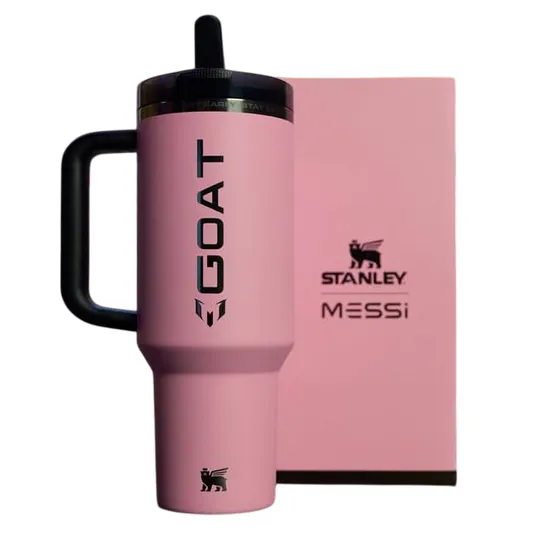 A pink Stanley tumbler with \“GOAT\“ and \“Messi\“ branding is displayed alongside a matching pink box.