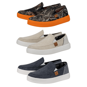 Three pairs of casual slip-on shoes, one with a camouflage pattern and orange sole, one in beige, and one in dark denim.