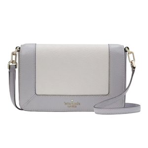 A compact Kate Spade crossbody bag with a chic two-tone design in light grey and cream, featuring gold-tone hardware and an adjustable strap.