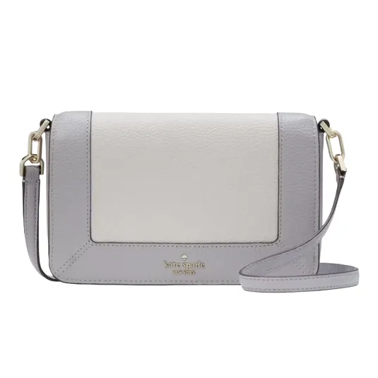 A compact Kate Spade crossbody bag with a chic two-tone design in light grey and cream, featuring gold-tone hardware and an adjustable strap.