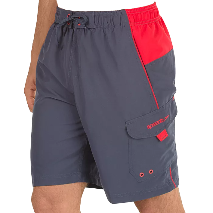 Gray swim trunks with red accents, featuring a drawstring waist, side pockets, and a cargo pocket with a flap and eyelets. \“Speedo\“ is embroidered on the cargo pocket flap.