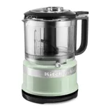A KitchenAid mini food processor in a light green color with a transparent bowl and black handle, featuring a chop and puree setting.