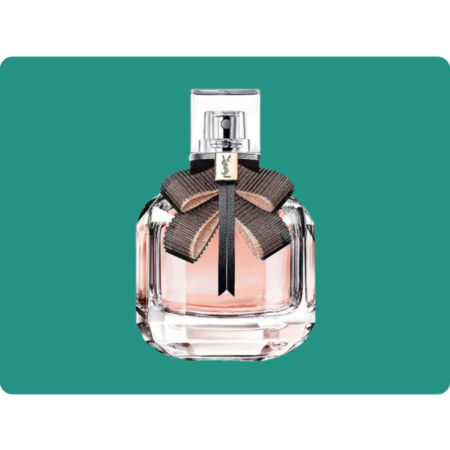 A perfume bottle with a transparent glass design features a pink liquid and a decorative ribbon bow with a small logo.