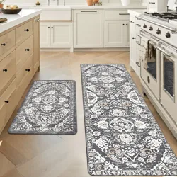 Two intricately patterned kitchen mats are placed on the floor in front of cabinets and a stove, offering both style and comfort in a kitchen setting.
