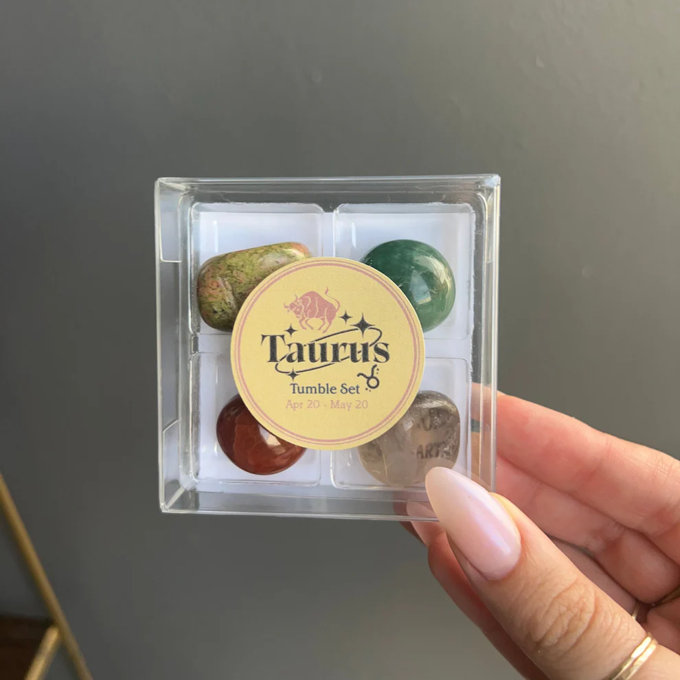 A Taurus Tumble Set containing four different tumbled stones in a clear square case, labeled with the Taurus zodiac dates (April 20 - May 20).