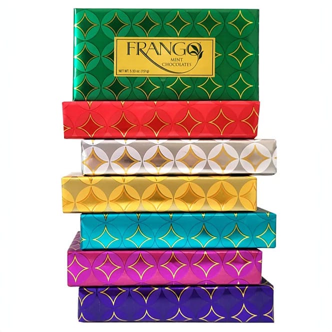 A stack of six colorful Frango Mint Chocolates boxes, each with a geometric pattern. Boxes are in green, red, silver, gold, teal, pink, and purple.