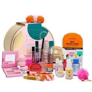 Sephora Advent Calendar featuring a variety of makeup and skincare items, including lip balm, mascara, glow booster mask, nail polish, eyeshadow palette, and bath bombs, all packaged in a round festive box.
