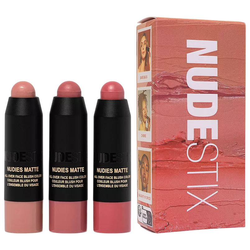 Three Nudestix Nudies Matte blush sticks in shades Bare Back, Cherie, and Naughty N' Spice are displayed alongside their packaging, featuring images of models using the blushes.