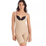 A woman wears a beige, sleeveless, full-body shapewear garment with shorts, designed to provide a slimming effect, paired with a black bra.