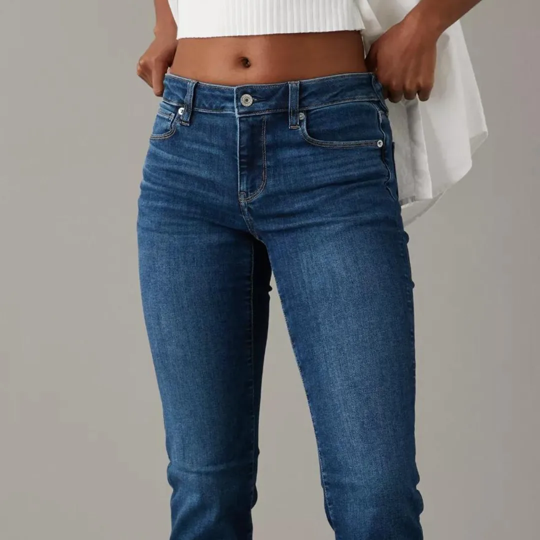 A person wearing blue jeans and a white top.