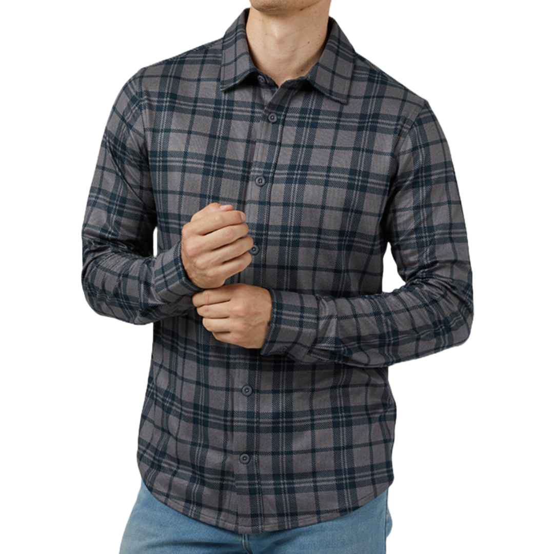 A man wearing a 32 Degrees Soft Stretch Shirt in a gray and blue plaid pattern, paired with light blue jeans. The shirt features a button-up front and long sleeves.