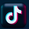 The logo for the social media platform TikTok on a dark blue background.