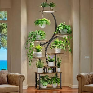 A vertical plant stand with multiple shelves displays various potted plants, arranged aesthetically in a living room corner. The stand features a modern, curving metal design, complemented by wooden shelves.