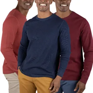 Three men wearing long-sleeve crew neck sweaters in red, navy blue, and burgundy, paired with beige, mustard, and blue pants.