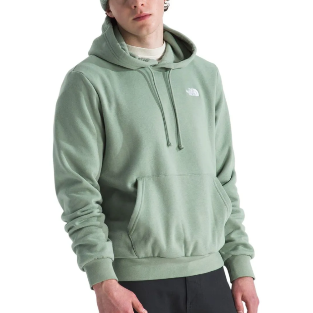 A person is wearing a light green North Face hoodie with a front pocket and drawstrings, paired with dark pants.