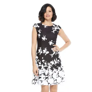 A woman in a sleeveless black and white floral dress.