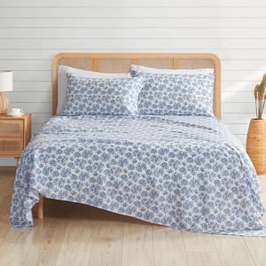 A bed made with a blue and white floral-patterned microfiber sheet set, including a fitted sheet, a flat sheet, and pillowcases.