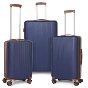 A 3-piece nested hardside luggage set in navy blue with brown accents features retractable handles, four spinner wheels per suitcase, and ribbed exteriors for durability. Sizes vary for versatile travel needs.