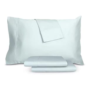 1,200 thread count cotton-blend sheet set in a light blue color, featuring a large pillowcase, stacked folded sheets, and an additional smaller folded sheet on top.