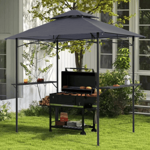 A steel grill gazebo with a dark canopy provides shade and cover for an outdoor grill setup. It features side shelves for additional space, has a black frame, and is positioned in a garden setting beside a house.