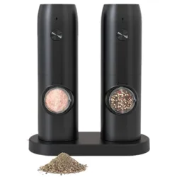A set of two black electric grinders, one containing pink Himalayan salt and the other mixed peppercorns, placed on a charging dock. A small pile of ground pepper is in front of the set.