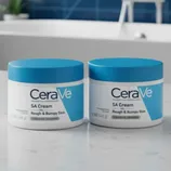 Two jars of CeraVe SA Cream for Rough & Bumpy Skin, each containing 12 oz (340 g), are displayed on a bathroom countertop with a blue-tiled wall and a bathtub in the background.