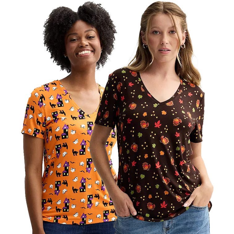 Two women wearing V-neck graphic t-shirts, one with a Halloween theme and the other with an autumn leaves pattern.
