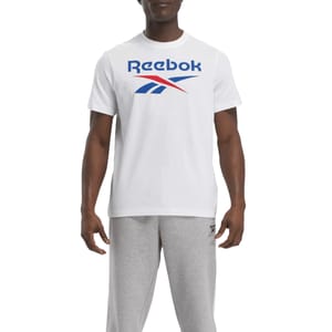A person is wearing a white Reebok t-shirt featuring the brand's logo in blue and red, paired with light gray sweatpants.