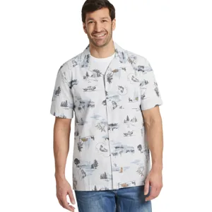 Man wearing a short-sleeve button-up shirt with a nature-themed print and blue jeans.