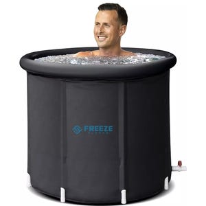 A man is sitting in a black cylindrical ice bath tub filled with ice water, branded \“Freeze Sleeve.\“