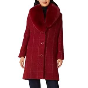 A woman wearing a red textured coat with a large collar and button front.