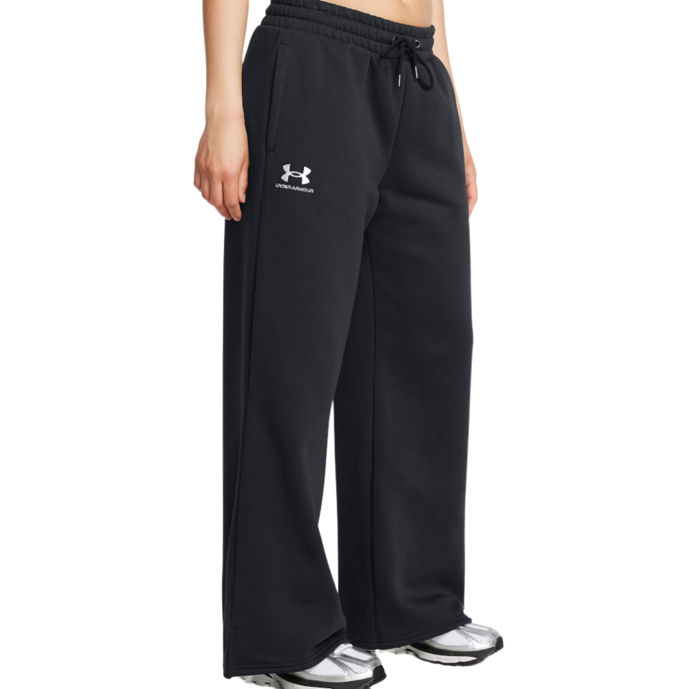 Black Under Armour sweatpants with a relaxed fit, featuring an elastic waistband, drawstring, and the brand logo on the left thigh, paired with gray and black athletic sneakers.