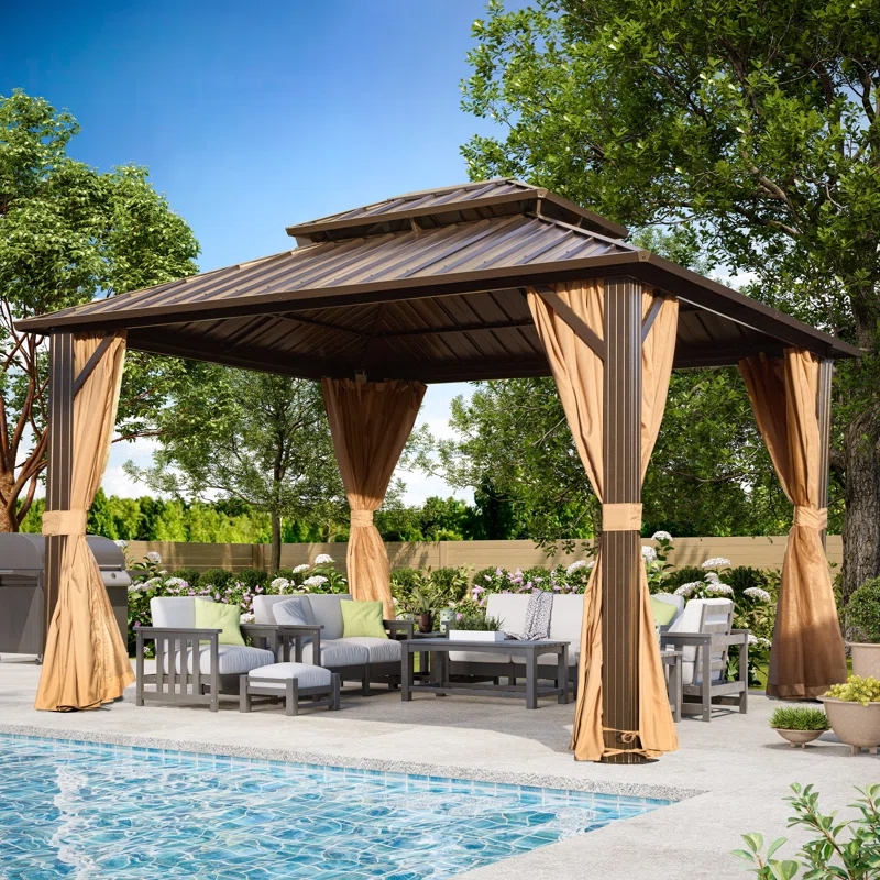 A hardtop gazebo with a metal roof and brown curtains is set by a poolside, featuring outdoor seating with gray cushions and green accent pillows. There are surrounding trees and potted plants, providing a shaded relaxation area.