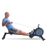 A person uses a rowing machine for exercise, featuring a digital display and a sleek design.