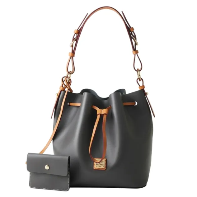 A dark gray bucket bag with tan leather straps and drawstring, featuring a small matching wallet attached by a strap.