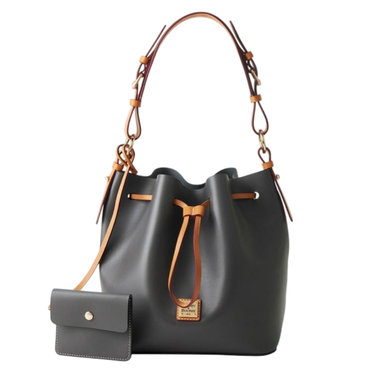 A dark gray bucket bag with tan leather straps and drawstring, featuring a small matching wallet attached by a strap.