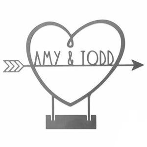 An 8-inch custom heart sign features a heart pierced by an arrow, with the names \“Amy & Todd\“ inside. The design includes a base for standing display, crafted in a sleek, minimalist style.