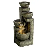 A cascading tiered fountain with a stacked bowl design and a stone-like finish features water flowing from top to bottom, creating a relaxing water sound.