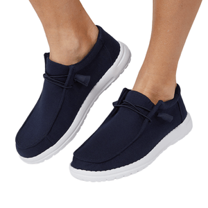 Navy blue slip-on shoes with white soles and minimalist design, featuring elastic laces for easy wear.
