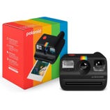 A Polaroid Go instant camera with a black body and rainbow stripe is displayed next to its colorful packaging. The camera is shown ejecting an instant photo.