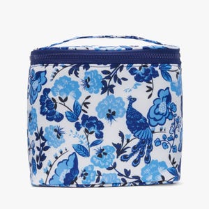 A lunch tote with a floral and peacock design in shades of blue on a white background, featuring a dark blue zipper and trim.