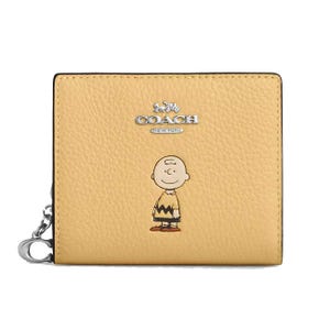 A yellow Coach wallet featuring a cartoon character illustration on pebbled leather, with a metal clip on the side.