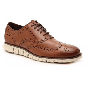 Brown leather wingtip oxford with perforated detailing and a contrasting lightweight, white athletic sole.