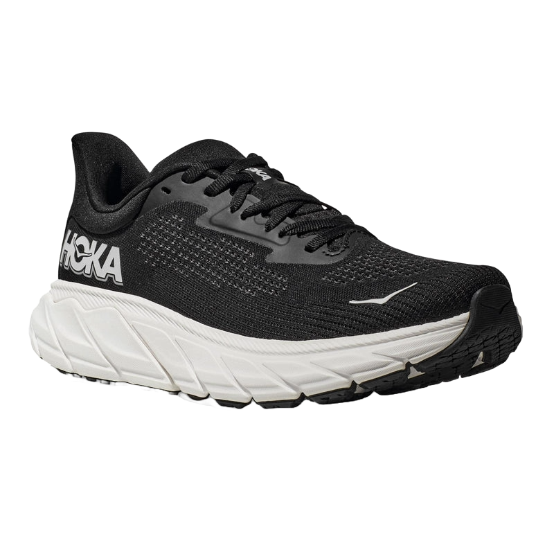 A black Hoka running shoe with a thick white sole, featuring Hoka branding on the side and a lace-up design.