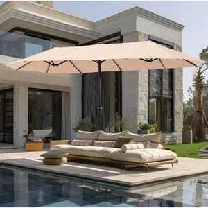 A 13-foot patio umbrella with a beige canopy provides shade over an outdoor sectional sofa next to a pool. The umbrella has a central pole and is set in a modern backyard with large windows, potted plants, and contemporary decor.