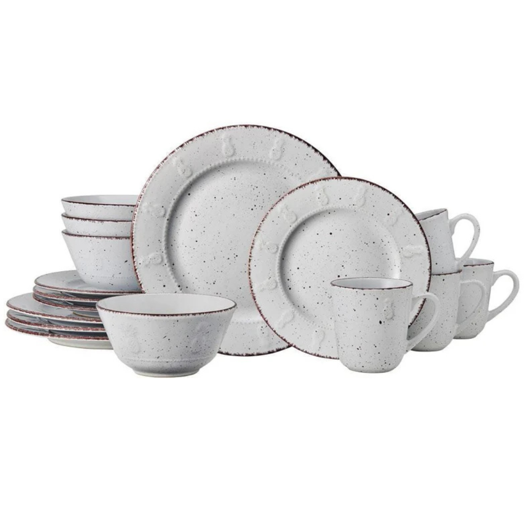A rustic speckled dinnerware set includes plates, bowls, and mugs with a textured design, featuring subtle brown edges for a vintage look.