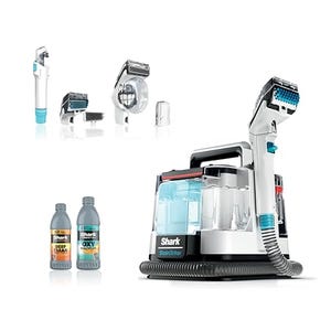 Shark StainStriker Carpet Cleaner is a portable cleaning device with various attachments, a hose, and two bottles of cleaning solution.