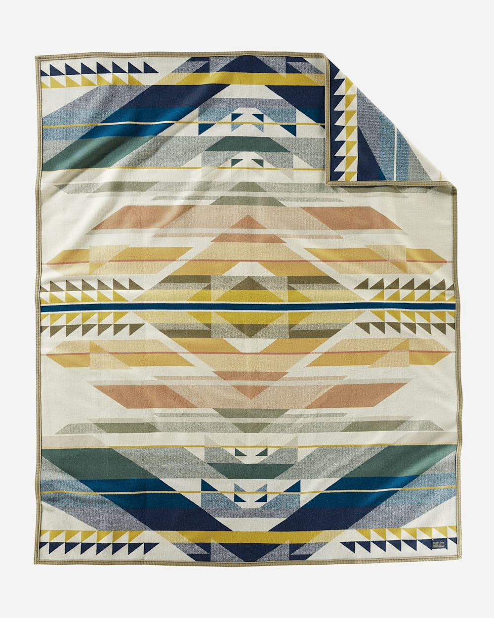 A blanket featuring a geometric, multicolored pattern with triangles and stripes in shades of blue, yellow, and earthy tones.